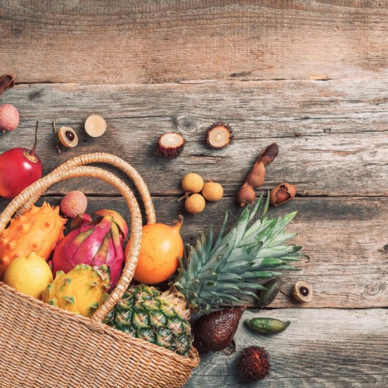 tropical-fruits-in-a-basket-on-wooden-background-top-view-copy-space-tropical-fruits-flat-lay.jpg